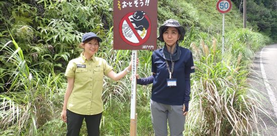 奄美野生生物保護センター提供：交通事故防止を呼び掛ける看板を設置した関係者ら＝１８日、瀬戸内町